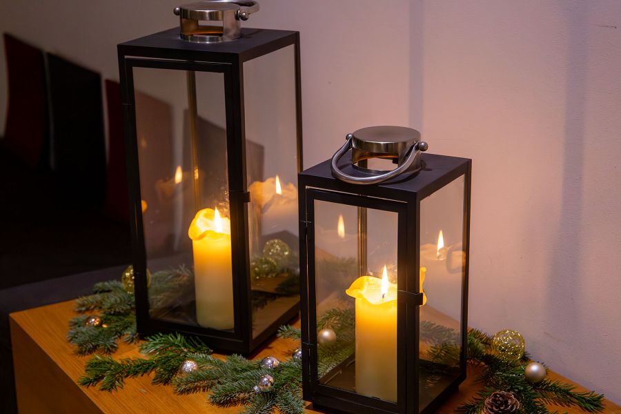 Zwei Windlichter mit brennenden Kerzen